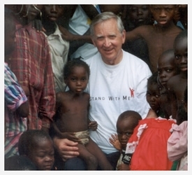 Richard Proudfit posing with the children. (The Kids Against Hunger Website (http://www.kidsagainsthunger.org/our_founder.shtml))