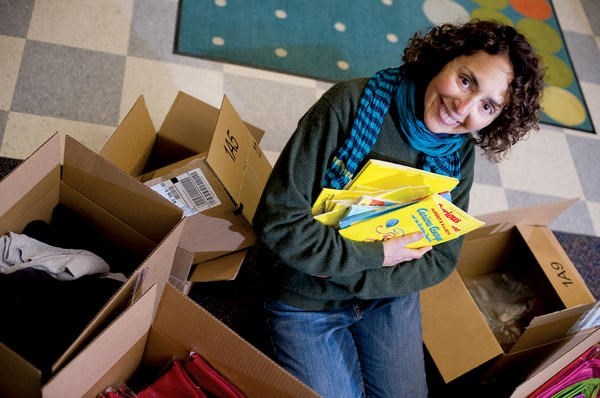 Pam Koner holds an armload of gently used books to be mailed to children in a less-advantaged town through her Giving Works! program.  <P>Ann Hermes/Staff