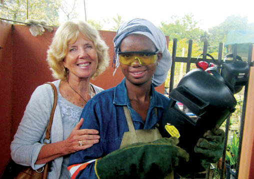 Libby Weir (l.) poses with Ntokozo Zulu, who is enrolled in a welding course that Ms. Weir is sponsoring. <P>David Canning