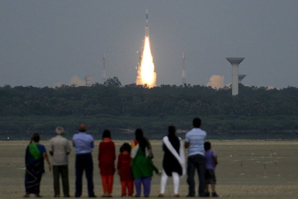 People watch as India's Geosynchronous Satellite Launch Vehicle blasts off carrying a GSAT-6 communication satellite from the Satish Dhawan space center at Sriharikota, India in August 2015. India's space agency said Monday it had launched a minature prototype of a reusable rocket into space from Sriharikota on Monday morning, a milestone as it focuses on reusable space craft. (Stringer/Reuters)