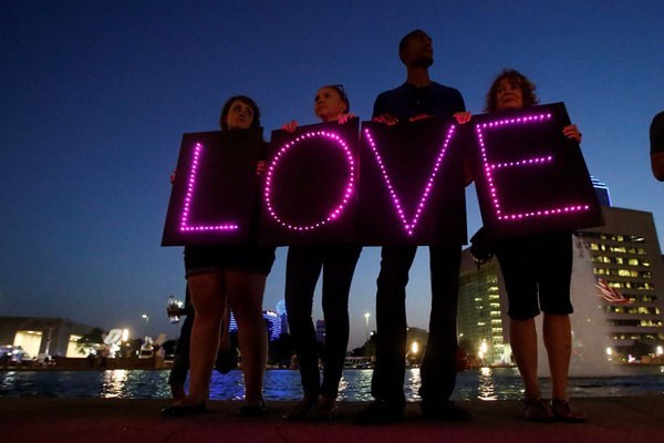Supporters hold lighted signs that read 'LOVE' during a July 11 candlelight vigil at Dallas City Hall following the deaths of five police officers at the hands of a shooter. Photo - Carlo Allegri/Reuters