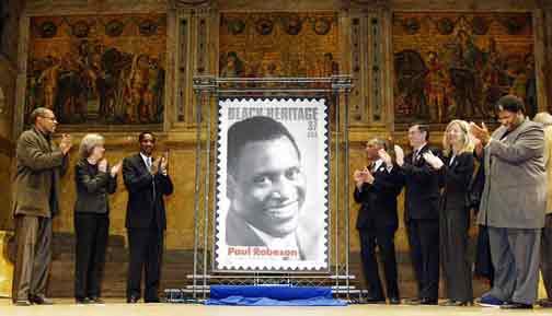 From left to right: Theatre Artist Avery Brooks, Princeton University President Shirley Tilghman, Vice President of Diversity Development for the Postal Service Murry Weatherall, Paul Robeson, Jr., Rep. Rush Holt, D-N.J., Princeton University Provost Amy Gutmann and NJ Secretary of State Regena Thomas applaud as a stamp honoring entertainer Paul Robeson is unveiled in Princeton, N.J., Tuesday, Jan. 20, 2004. The stamp is the newest addition to the Black Heritage Stamp Collection. (AP Photo/Tim Larsen)