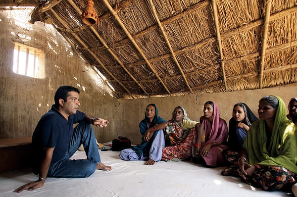   Anshu Gupta (l.), founding director of GOONJ, speaks to women in Rupaspur, a rural village in northeast India.  <P>Manan Vatsyayana/AFP/Getty Images/file