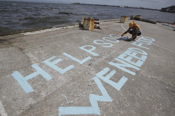 A survivor writes a message to call for help in typhoon-ravaged Tacloban, central Philippines, on Monday, Nov. 11. Authorities said at least 2 million people in 41 provinces were affected by the typhoon.  <p>Aaron Favila/AP