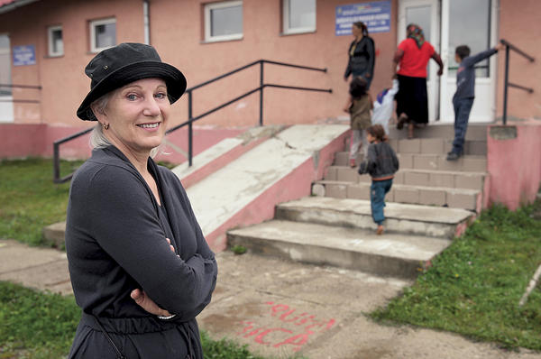 Leslie Hawke, cofounder of the Romanian NGO OvidiuRo, watches as Roma children arrive for preschool in Ponorata, Romania.  <P>Sean Gallup/Getty Images