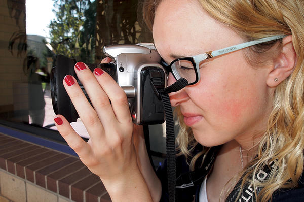Dallas Jessup looks through a digital camera. The recent college graduate has already produced two films that teach basic self-defense. <P>Just Yell Fire