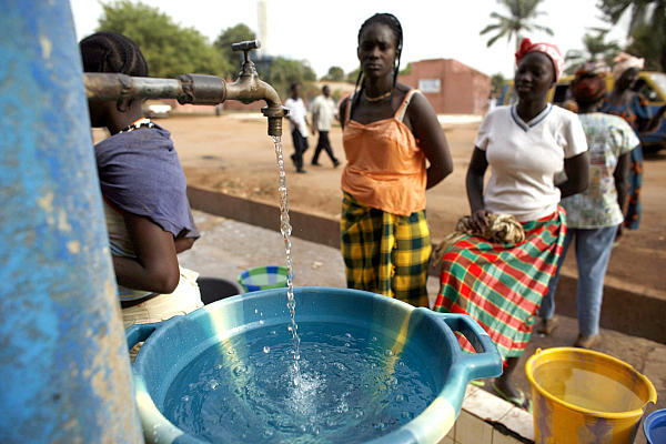Girls fill plastic basins at a free water tap operated by a charity in a neighborhood of Bissau, Guinea-Bissau, where houses rarely receive water. Water supplies are insufficient to meet even the capital city's needs, and contaminated drinking water leads to epidemics. Scott Harrison's Charity:Water hopes to raise $2 billion to get clean water to 100 million more people.  <P>Rebecca Blackwell/AP/File