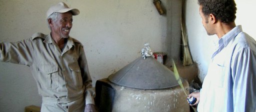 Debessai Ghebrehiwot (right) from the ERTC, talking with an owner of an improved stove.