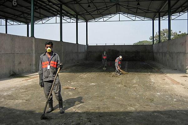 Workers at the Bulta CDM plant clean out a composting area for market waste.