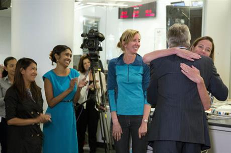 Gary Pruitt, back to camera, President and CEO of The Associated Press, embraces reporter Martha Mendoza as the AP wins the Pulitzer Prize for public service, Monday, April 18, 2016 in New York. Mendoza, Robin McDowell, center, Esther Htusan, far left, and Margie Mason, not seen, chronicled how men from Myanmar and other countries were being imprisoned, sometimes in cages, in an island village in Indonesia and forced to work on fishing vessels. AP's international enterprise editor Mary Rajkumar, second left, also congratulated the reporters. (AP Photo/Mark Lennihan)