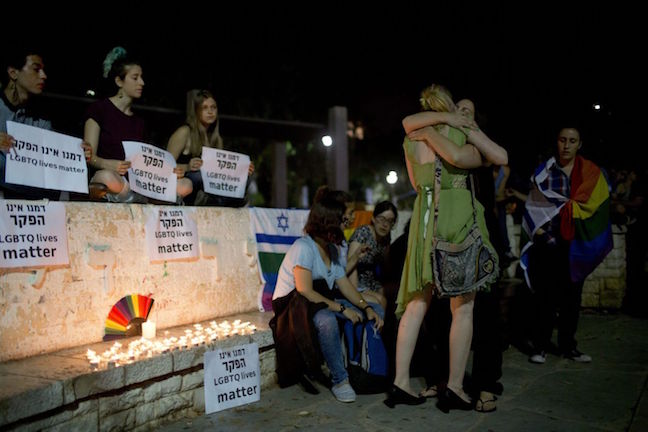 Members LGBT community light candles in solidarity with Florida's shooting attack victims in Tel Aviv, Israel, Sunday, June 12, 2016.  Oded Balilty/ AP