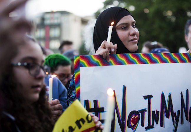 A Muslim woman holds a candle and a sign reading '#NotInMyName' to show that many in the Islamic faith support the LGBTQ community after the Orlando shooting, Seattle, U.S., June 12, 2016. Credit - Lindsey Wasson, AP