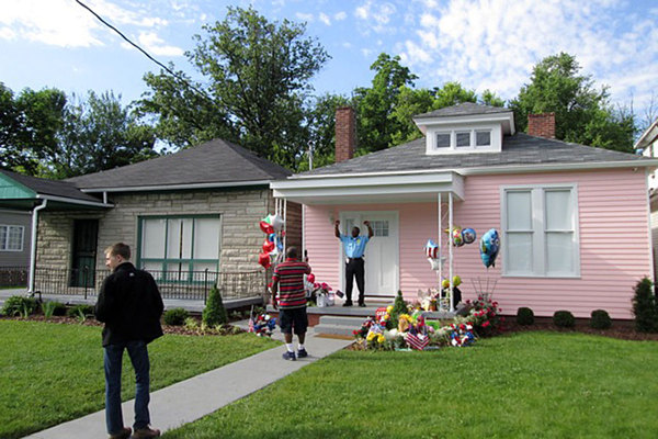 A law enforcement officer (on duty at the house) mugs for a visitor in front of Muhammad Ali's childhood home in Louisville, Ky. Photo - Ruth Walker