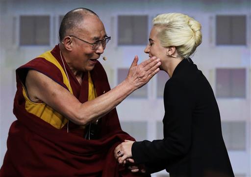 The Dalai Lama greets Lady Gaga, right, before a question and answer session at the U.S. Conference of Mayors in Indianapolis, Sunday, June 26, 2016. (AP Photo/Michael Conroy)