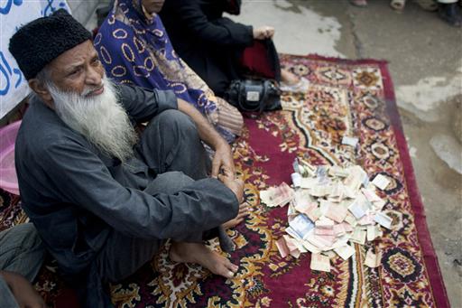 In this Monday, Aug. 2, 2010 file photo, Pakistan's humanitarian leader Abdul Sattar Edhi collects donations at a roadside in Peshawar, Pakistan. The family of Pakistan's legendary philanthropist Abdul Sattar Edhi say he has died at a hospital in Karachi. (AP Photo/Anjum Naveed, File)