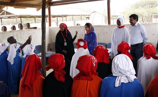 Malala Yousafza, center right in blue, meets refugee girls in Dadaab, Kenya, Tuesday, July 12, 2016. Nobel laureate Malala Yousafzai is spending her 19th birthday in Kenya Tuesday visiting the world's largest refugee camp to draw attention to the global refugee crisis, especially as Dadaab camp faces pressure to close after a quarter-century. (AP Photo/Khalil Senosi)