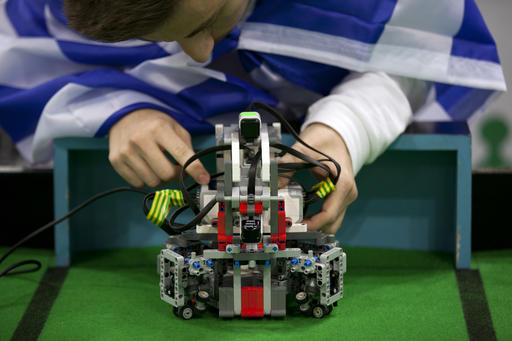 In this Sunday, Nov. 27, 2016 photo, a participant from Greece gets his robot ready for a game of soccer at the World Robot Olympiad in New Delhi, India. The weekend games brought more than 450 teams of students from 50 countries to the Indian capital. (AP Photo/Tsering Topgyal)