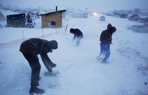 Campers shovel out an exit ramp at the Oceti Sakowin camp where people have gathered to protest the Dakota Access oil pipeline in Cannon Ball, N.D., Tuesday, Dec. 6, 2016. Many Dakota Access oil pipeline opponents who've gathered for months in the camp are committed to staying despite wintry weather and demands that they leave. An overnight storm brought several inches of snow, winds gusting to 50 mph and temperatures that felt as cold as 10 degrees below zero. (AP Photo/David Goldman)