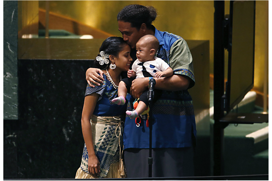 Kathy Jetnil-Kijiner(l.), civil society representative from the Marshall Islands, is greeted onstage by her husband and baby after speaking during the Climate Summit at United Nations headquarters in New York, Sept. 23, 2014. Photo: Mike Segar/Reuters