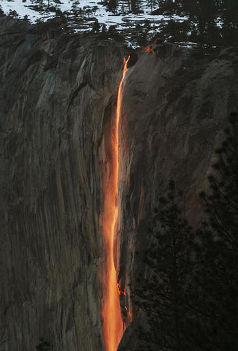 In this Feb. 16, 2010, file photo, a shaft of sunlight creates a glow near Horsetail Fall, in Yosemite National Park, Calif. Mother Nature is again putting on a show at California’s Yosemite National Park, where every February the setting sun draws a narrow sliver on a waterfall to make it glow like a cascade of molten lava. The phenomenon known as “firefall” draws scores of photographers to the spot, which flows down the granite face of the park’s famed rock formation, El Capitan. (Eric Paul Zamora/The Fresno Bee via AP)