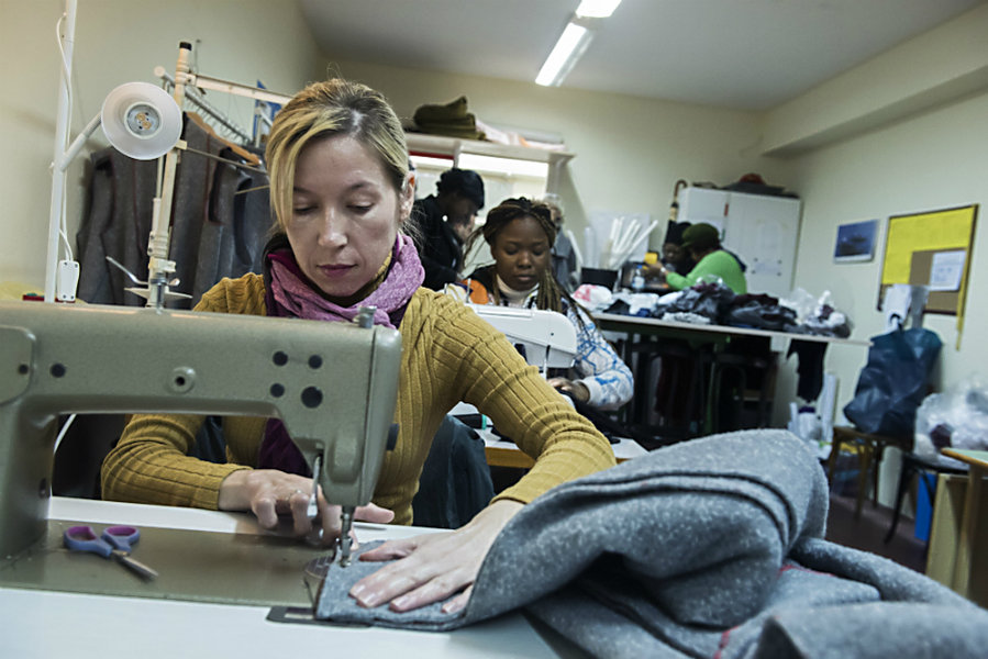 A migrant sews a blanket at a tiny coat workshop charity called naomi in the northern greek city of Thessaloniki, JAN. 30. The group is working long hours to collect and wash discarded blankets and turn them into wearable coats for refugees, who are facing a harsh winter. Photo: Giannis Papanikos/AP
