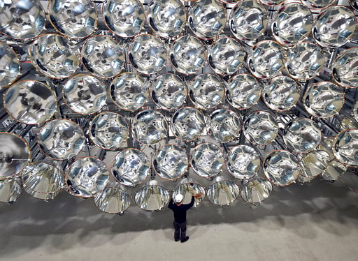 In this March 21, 2017 photo engineer Volkmar Dohmen stands in front of xenon short-arc lamps in the DLR German national aeronautics and space research center in Juelich, western Germany. The lights are part of an artificial sun that will be used for research purposes. (Caroline Seidel/dpa via AP)
