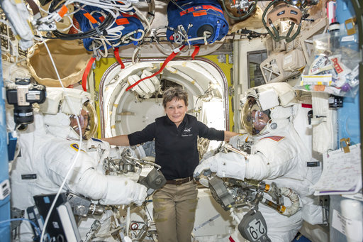 In this Jan. 13, 2017 photo made available by NASA, astronaut Peggy Whitson, center, floats inside the Quest airlock of the International Space Station with Thomas Pesquet, left, and Shane Kimbrough before their spacewalk. On Wednesday, April 5, 2017, NASA announced that Whitson will remain on the ISS until September 2017, adding three months to her original mission. (NASA via AP)