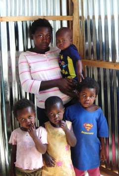 Suzan and her children inside her new shack