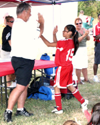 Jack Hitchens gives a high five to a U12 player. (Hannah Leake)