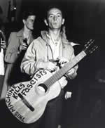 Woody With His Famous Guitar (http://isiria.files.wordpress.com/2007/07/woody-guthrie.jpg)