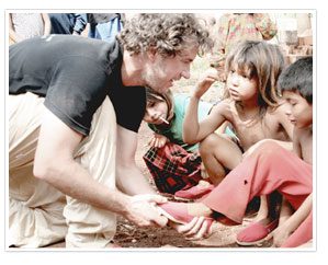 Blake giving poor children shoes (http://www.toms.com/blakes-bio ())